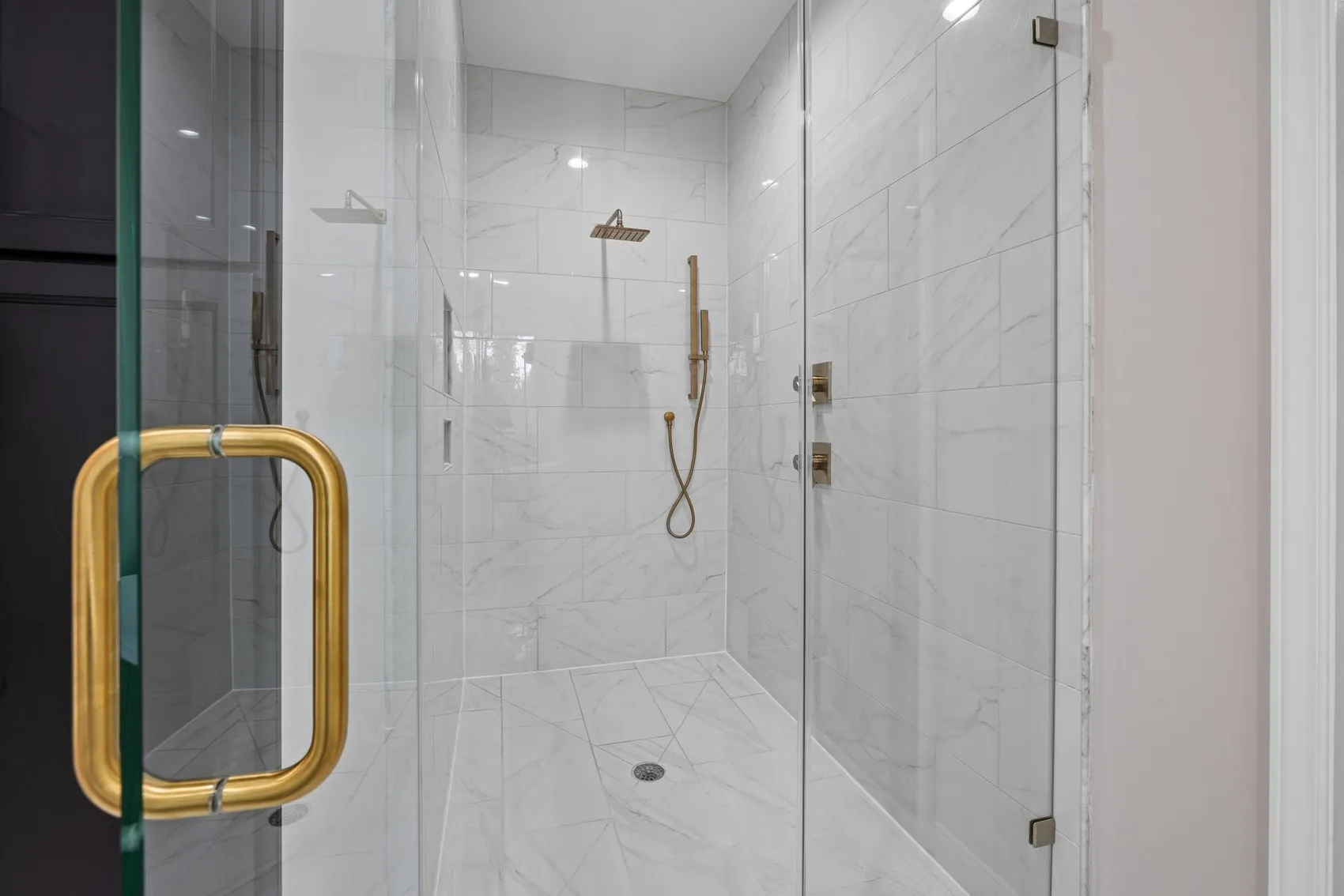 Marble tile shower with brass fixtures